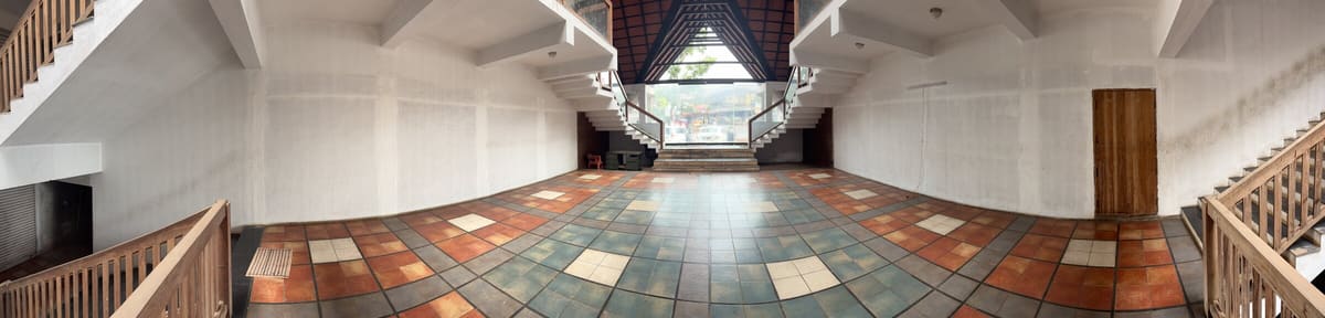Wide central court with patterned tiled floor, staircases, and skylight