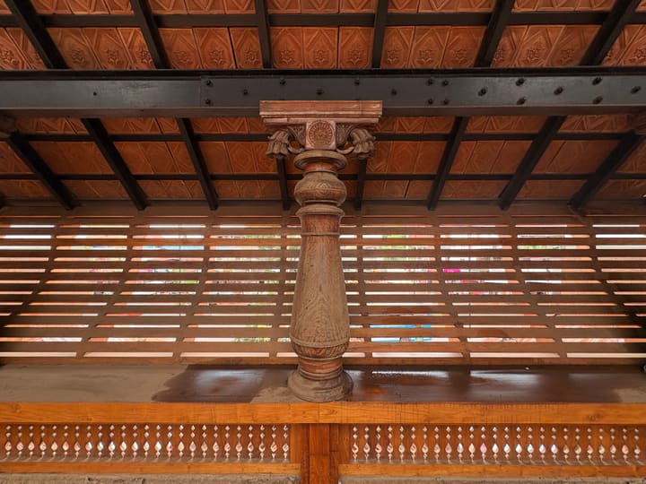 Second-floor traditional column and roof detail at nalukettu